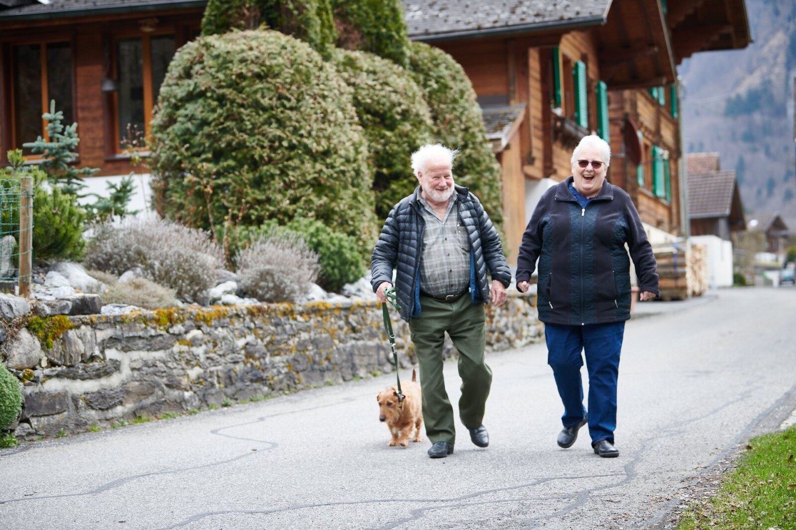 Ein älterer Mann und eine Frau auf einem Spaziergang mit einem Hund